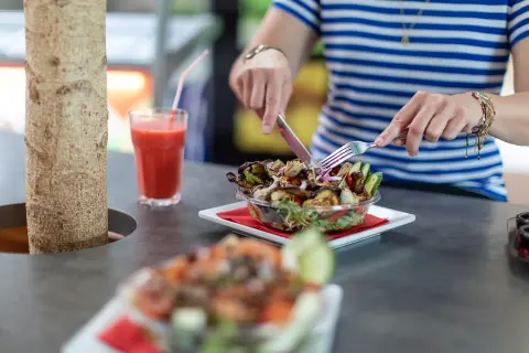 Ballini villa arena klant met salade aan bar met smoothie