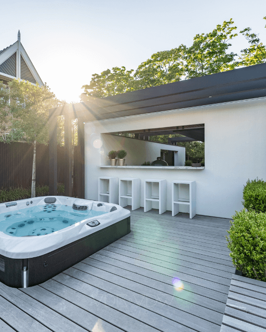 Buitenbar met witte krukken en jacuzzi in moderne achtertuin
