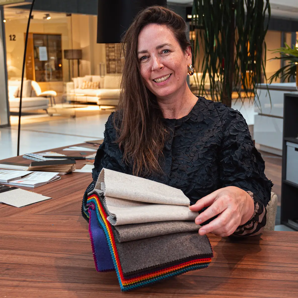 Dorien geeft persoonlijk interieuradvies bij Villa ArenA in Amsterdam en toont diverse stofstalen aan tafel.