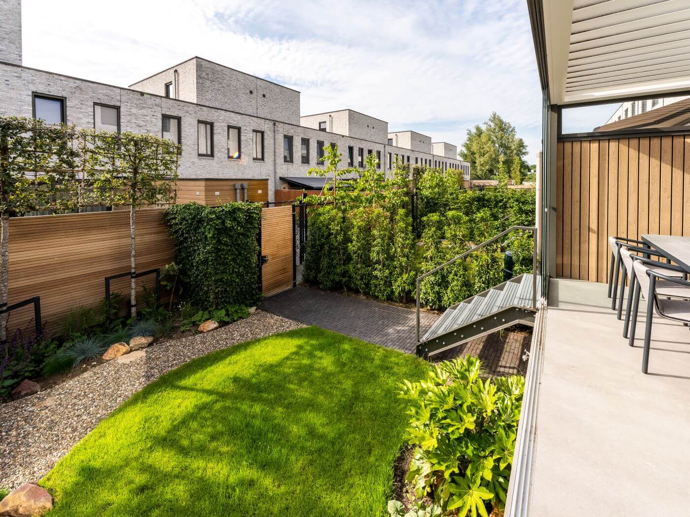 Eigentijds tuin ontwerp terras overkapping grote tegels dining tafel (5)