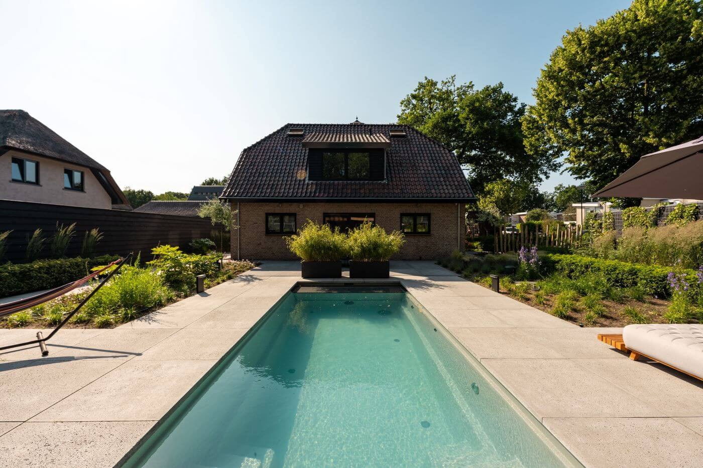Exclusieve tuin in Rhenen met een luxe zwembad, omgeven door hoogwaardige materialen