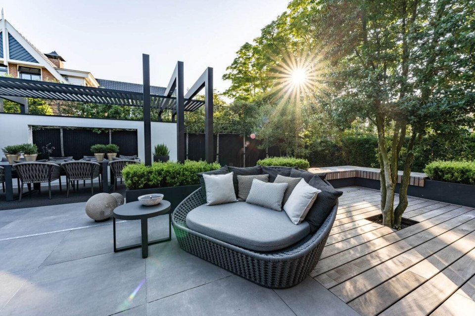 Loungetuin met moderne tuinmeubels en grote pergola van aluminium