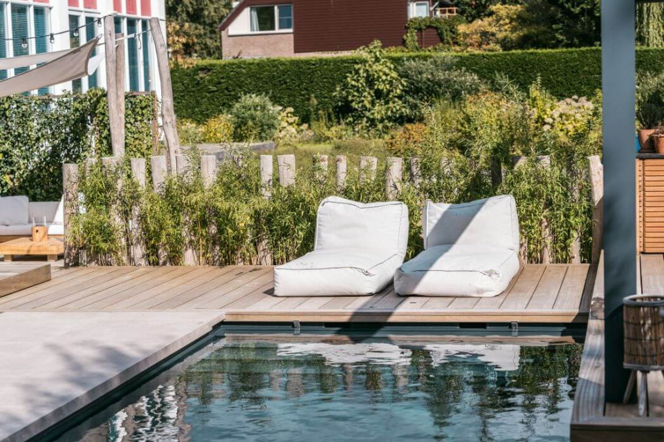 Luxe Balinese tuin met bamboe en flagstones rondom een zwembad