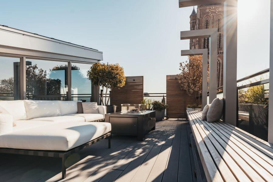 Modern dakterras ontwerp lounge set vuurtafel bank stalen elementen pergola planten potten meerstammigebomen siergrassen top10 (1)