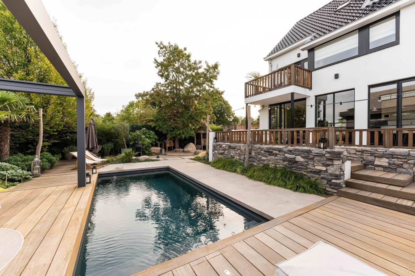 Stijlvolle tuin met steenstrips en bamboe, gecombineerd met tropische beplanting en flagstones.